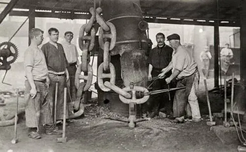 Historical photograph of metalworkers forging anchor chain links at Netherton forge in 1910