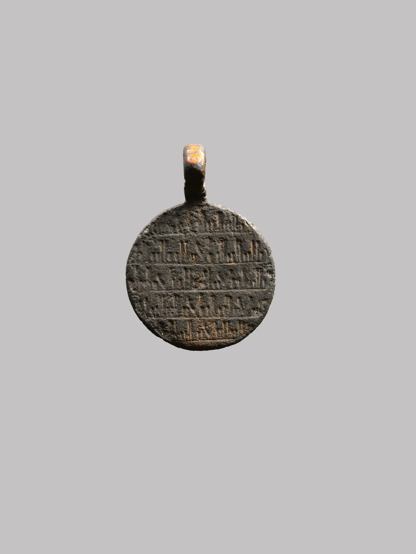 Colgante amuleto de plata con figuras grabadas de un león y un escorpión y una inscripción árabe