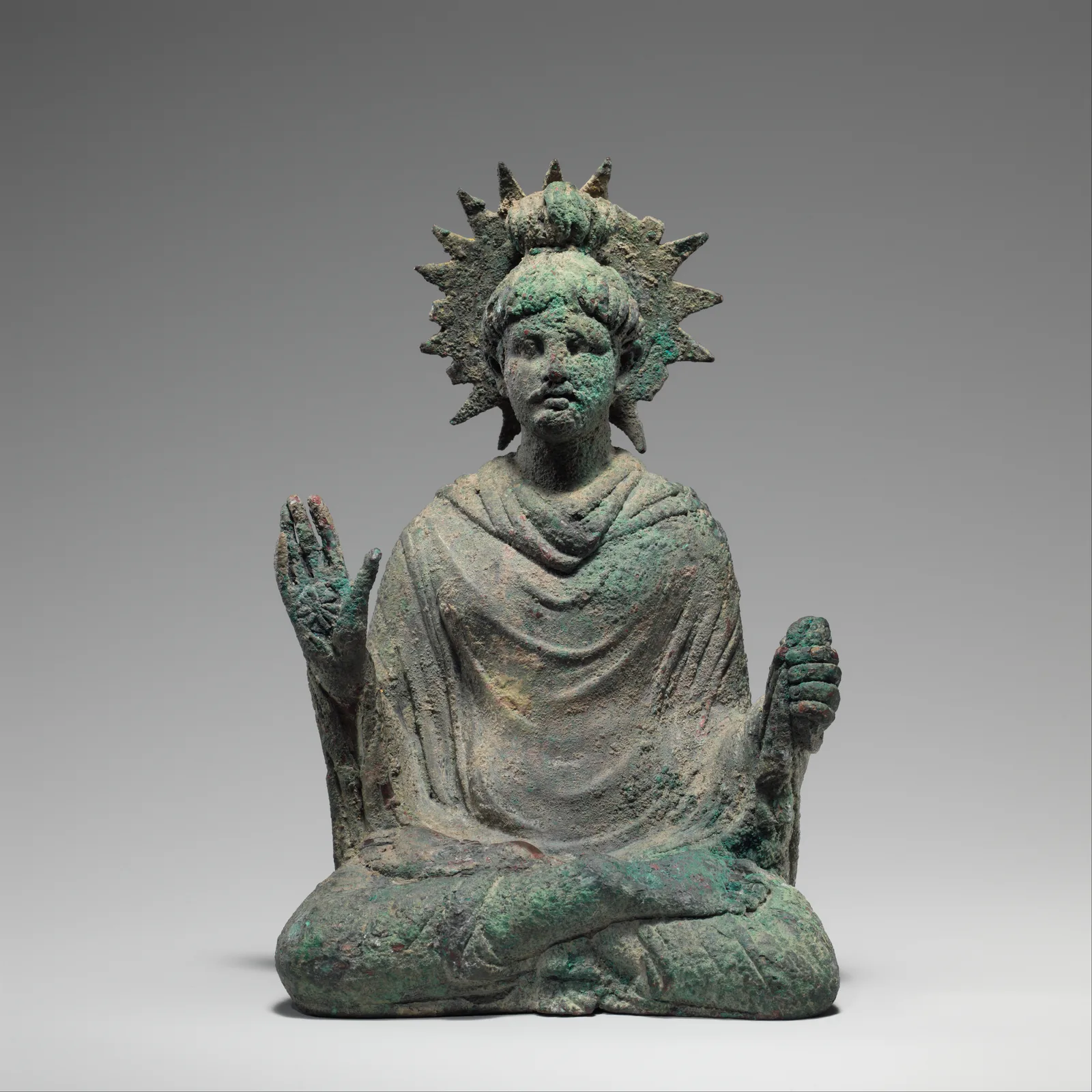 Buda sentado de piedra de época temprana, con el rostro sereno y rasgos clásicos