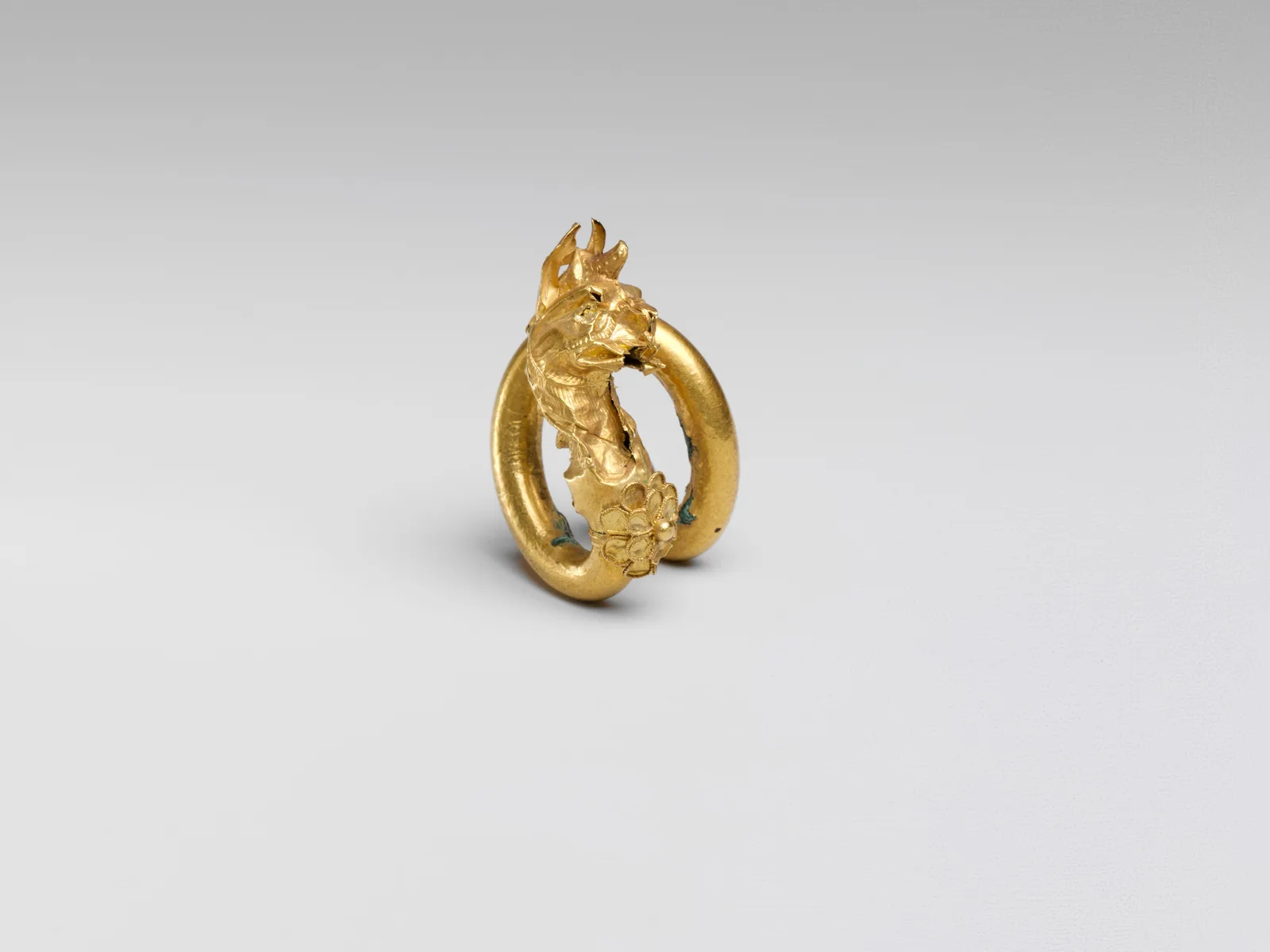 Espiral de bronce dorado con remate en forma de grifo, obra chipriota hacia el año 400 antes de nuestra era