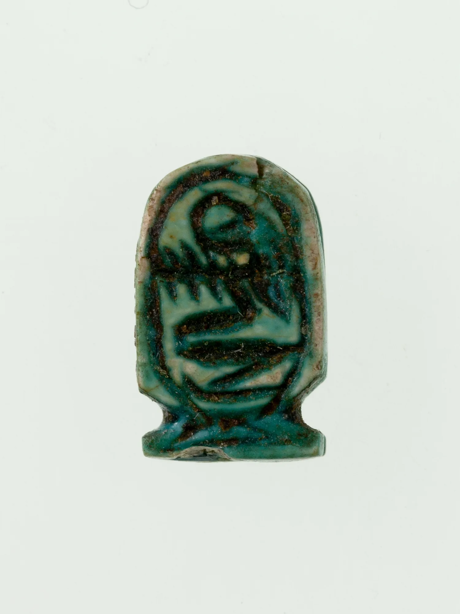 Amuleto del antiguo Egipto en forma de cartucho de esteatita vidriada con el nombre del faraón Amenemhat III dentro del óvalo
