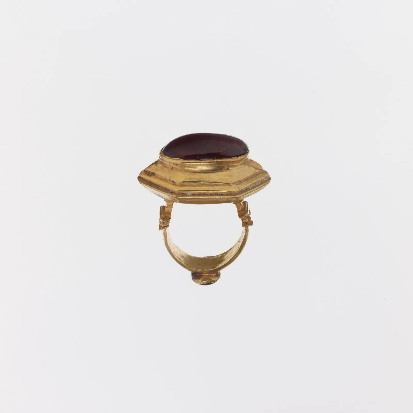 Anillo griego antiguo de oro con un granate de cabujón liso y abombado