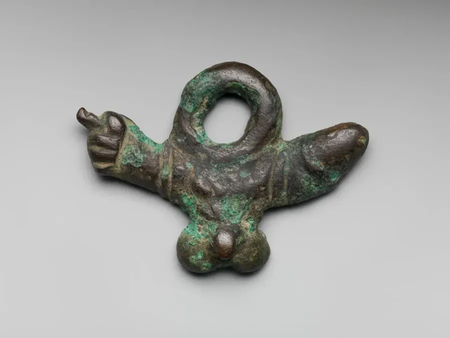 Amuleto romano de bronce, fascinum, siglo I d. C., talismán protector contra el mal de ojo