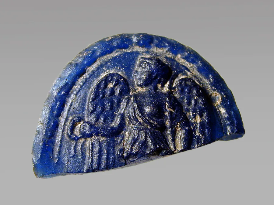 Medallón de vidrio romano del siglo I con la diosa alada Victoria sosteniendo una corona de laurel