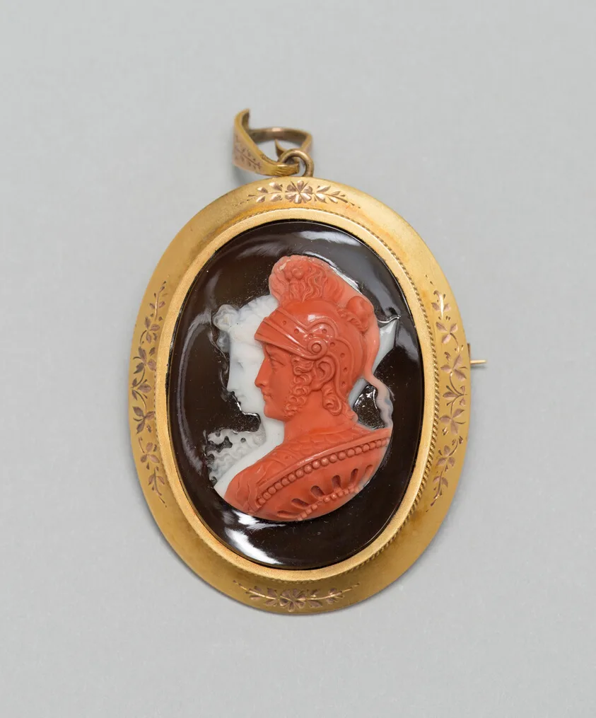 Antiguo broche colgante con un camafeo tallado de tema marino