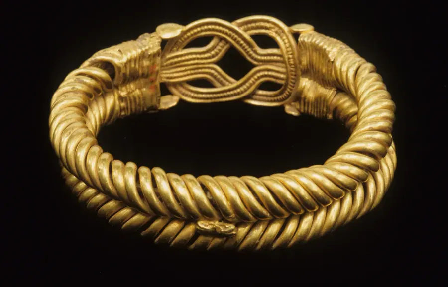 Brazalete romano de oro con hebras enroscadas en espiral y nudo de Heracles en el centro, siglo II d. C.