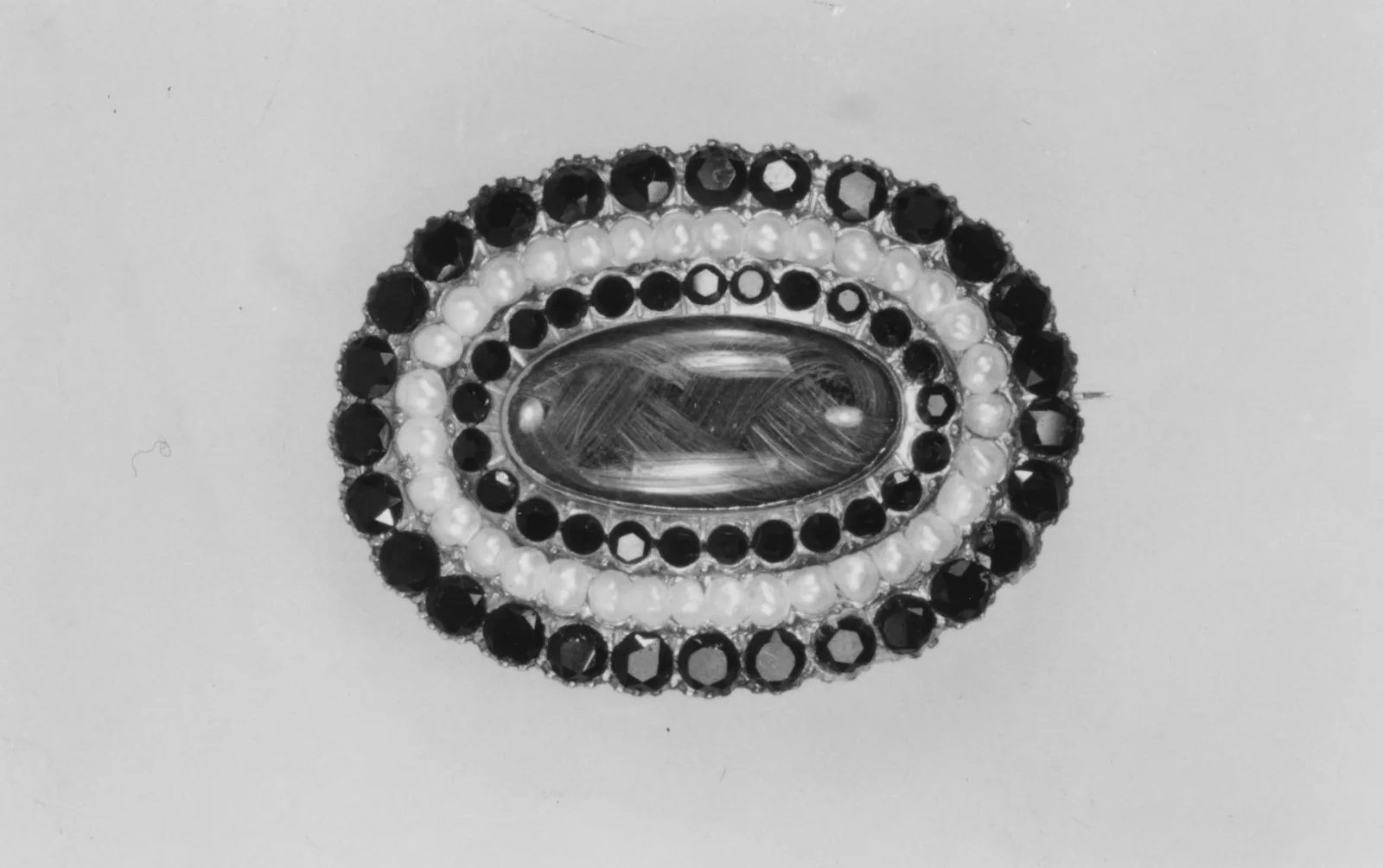 Alfiler de luto de oro con azabache negro y perlas, con un mechón de cabello en el centro, 1862