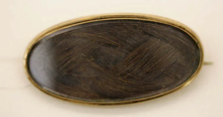 Broche sentimental del siglo diecinueve con un mechón de cabello trenzado bajo cristal en montura de oro, 1847