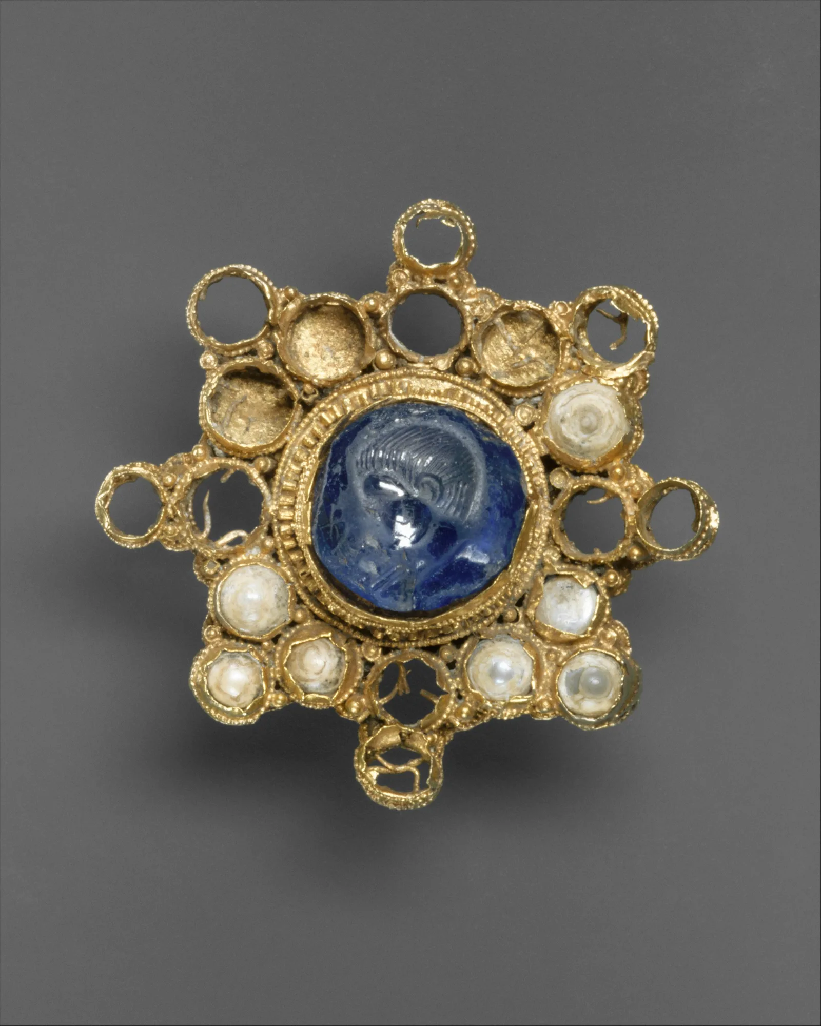 Broche medieval de oro con un gran zafiro estrellado y perlas, siglo X