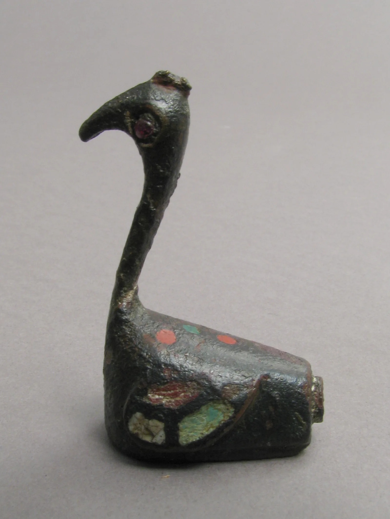 Broche de bronce en forma de pavo real con esmalte alveolado de colores y un cabujón de granate, labor romana del siglo II o III