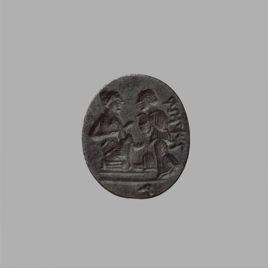 Anillo de bronce antiguo con una intaglio tallada, cubierto de patina verde oscura