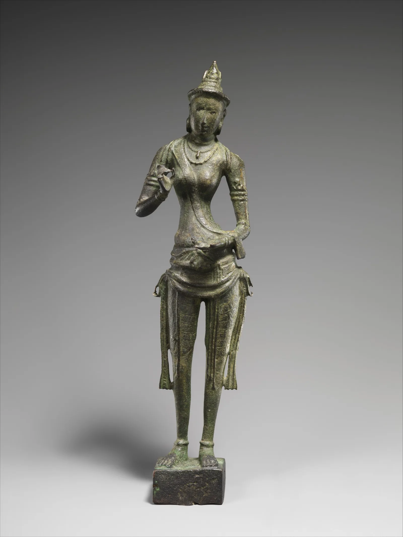 Figura de bronce de una diosa india de pie, postura serena y acabado sobrio, siglos VI-VII, Andhra Pradesh