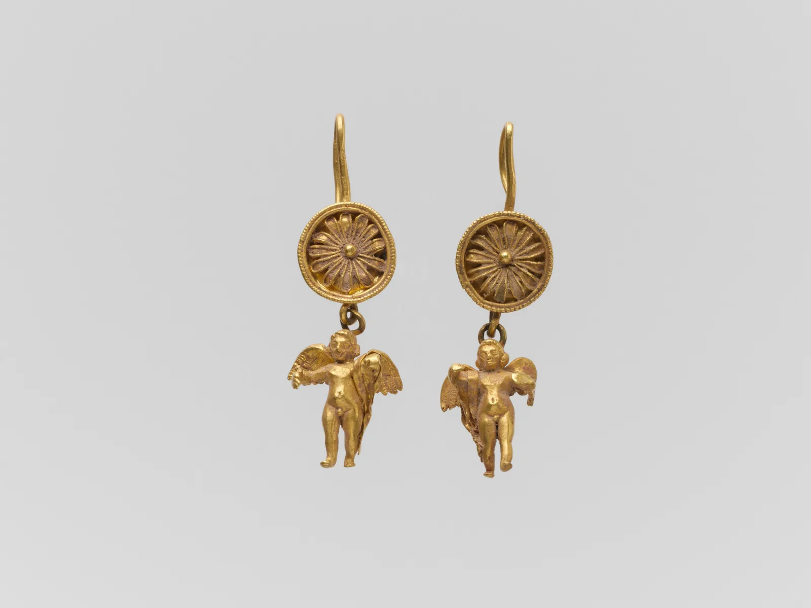 Par de pendientes de oro de disco con figuritas colgantes de Erotes, Grecia helenística
