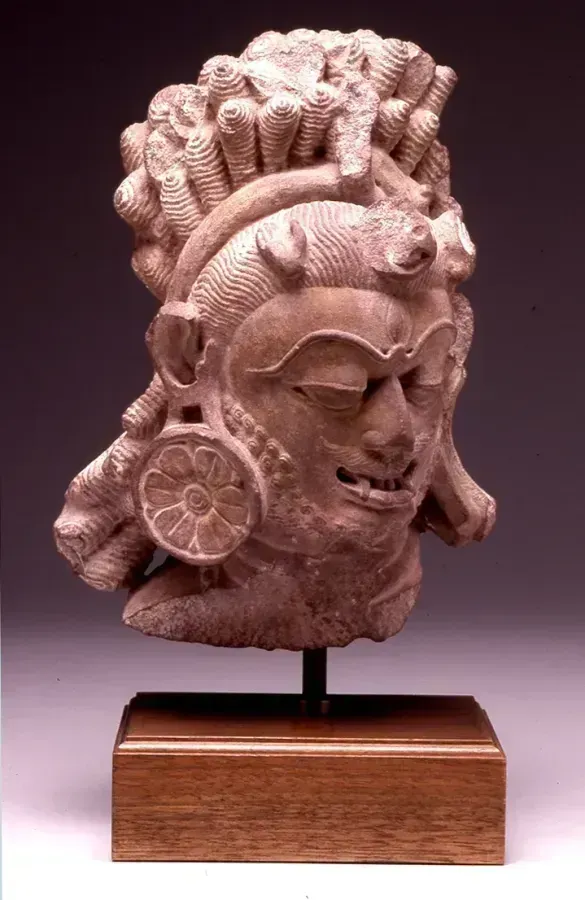 Cabeza de piedra de Shiva como Bhairava iracundo con el tercer ojo bien abierto, India, siglo XI