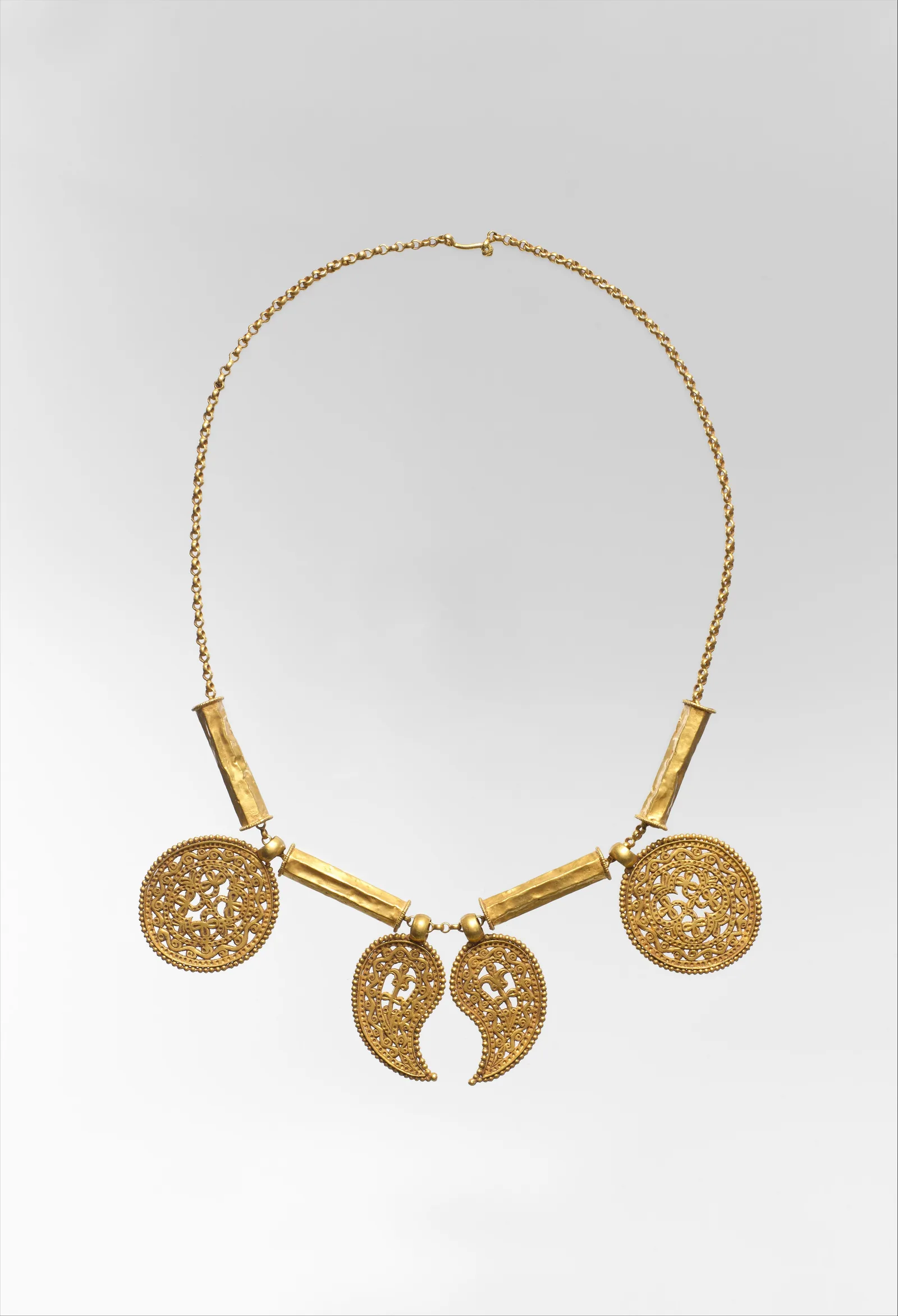 Collar largo de oro con colgantes sobre una cadena fina