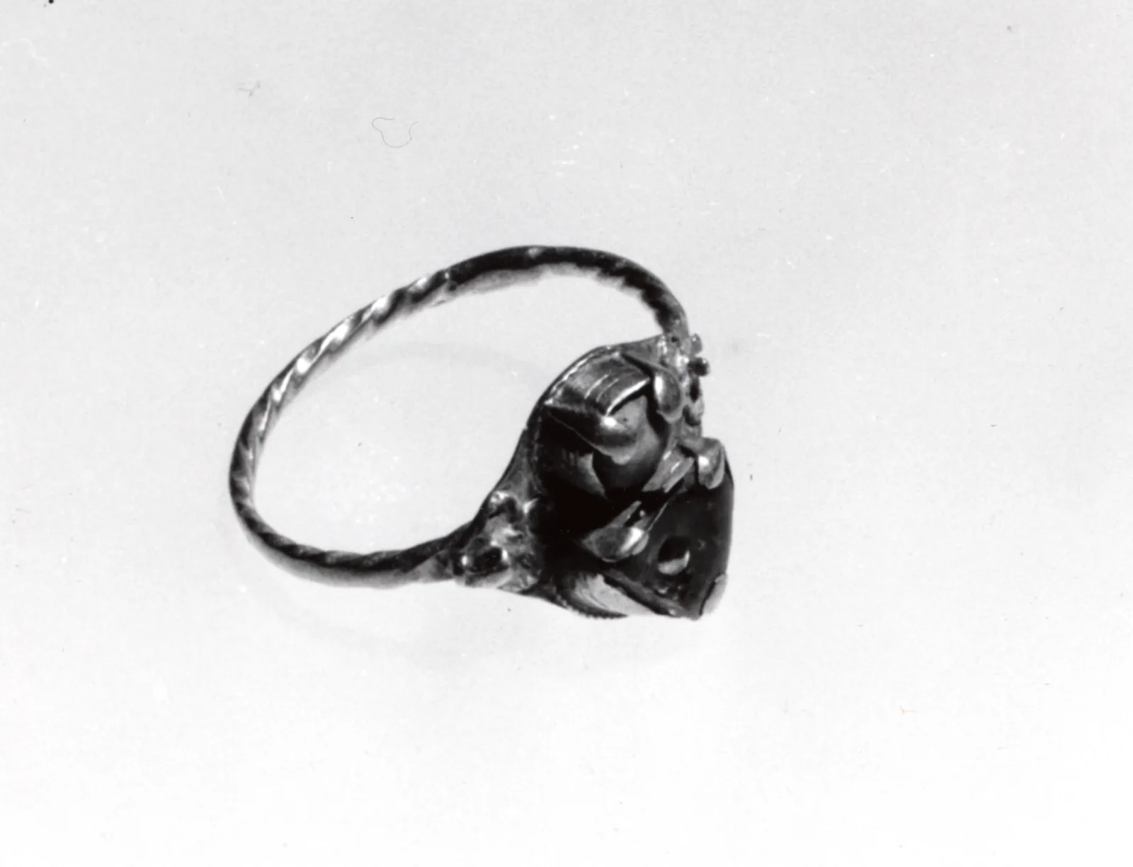 Antiguo anillo de oro con una piedra de color firmemente encajada en un engaste cerrado de bisel