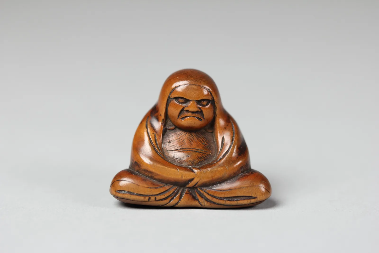 Netsuke de madera con la figura sentada del Daruma